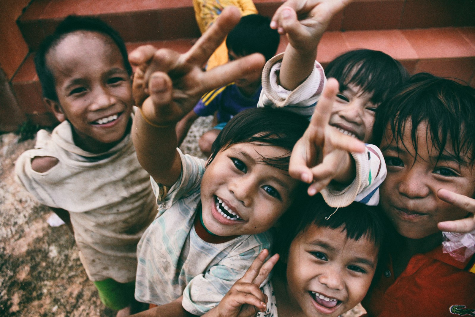 Primary school students raising hands eagerly during a class discussion